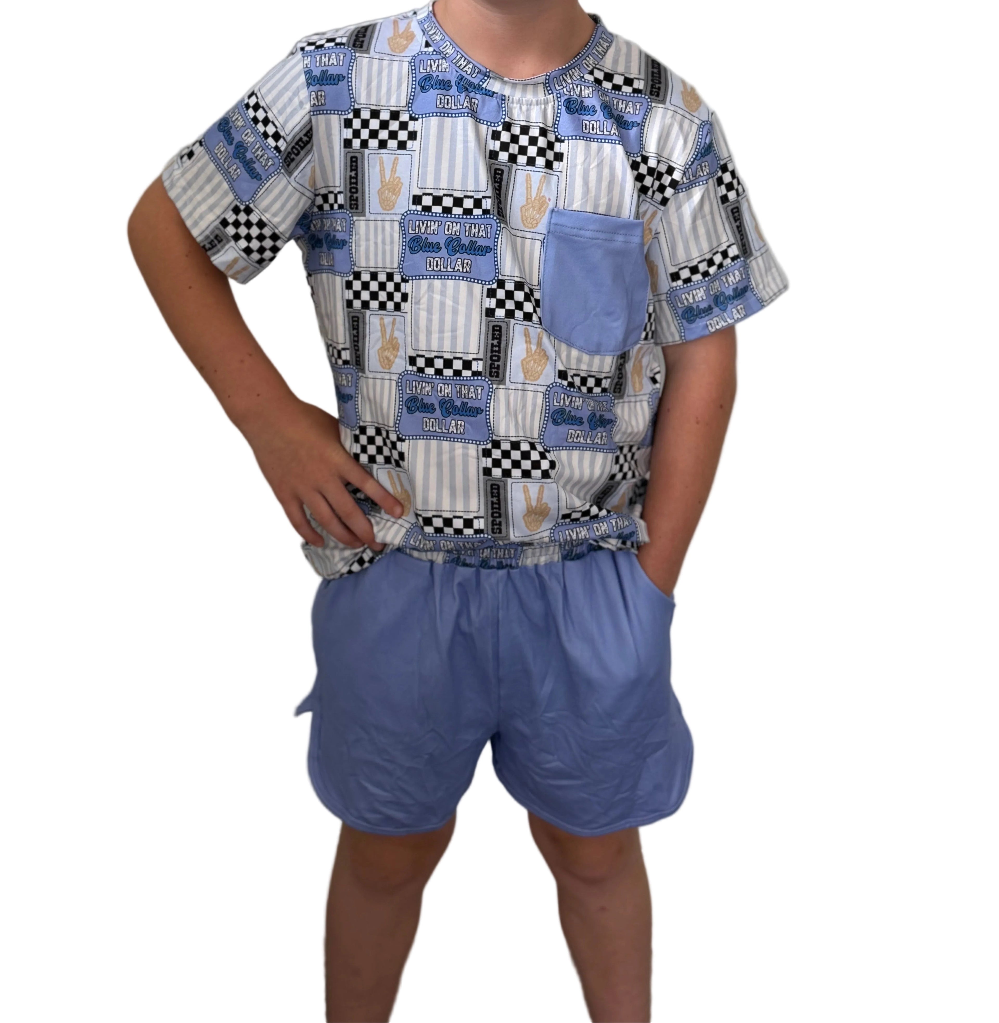 Child wearing a patterned shirt and blue shorts against a plain background