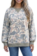 Person wearing a camouflage sweatshirt and blue jeans outdoors.