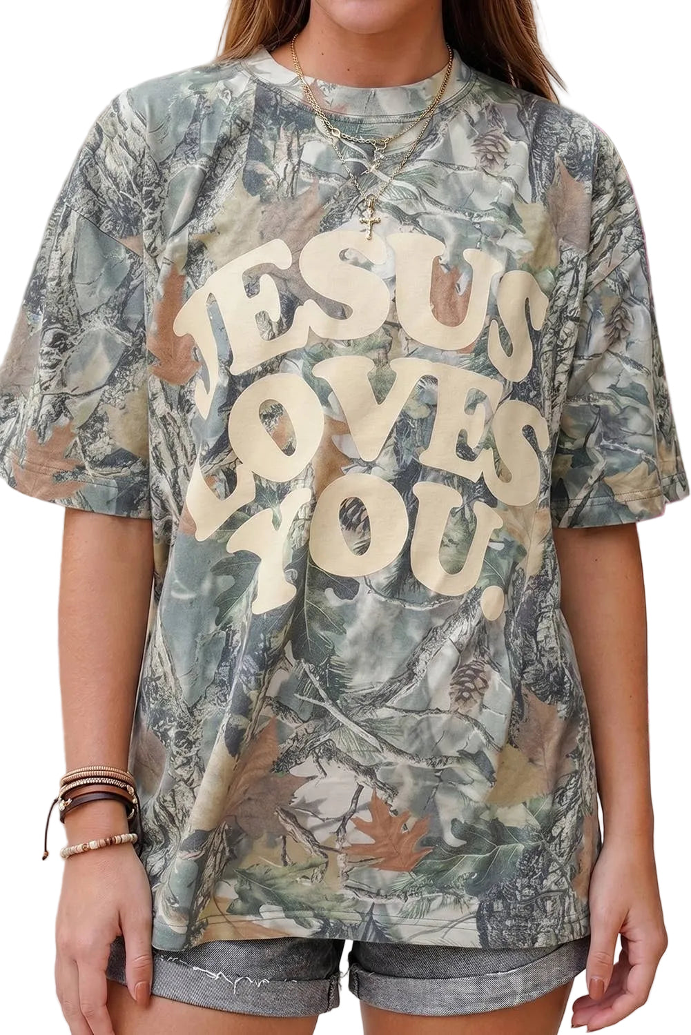 Person wearing a camouflage t-shirt with 'Jesus Loves You' text.