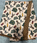 Baby blanket with hunting-themed design on a textured surface